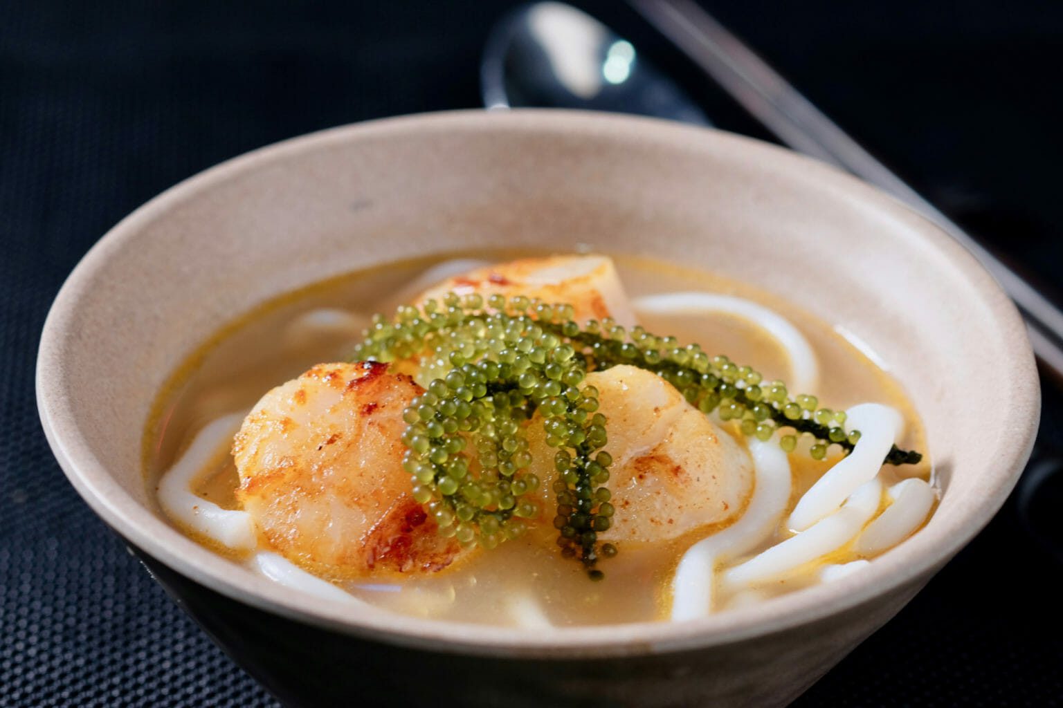 Udon noodles in salmon head broth with seared scallops delectabilia