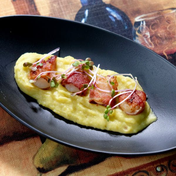 Scallops wrapped in pancetta on a sweet potato puree delectabilia