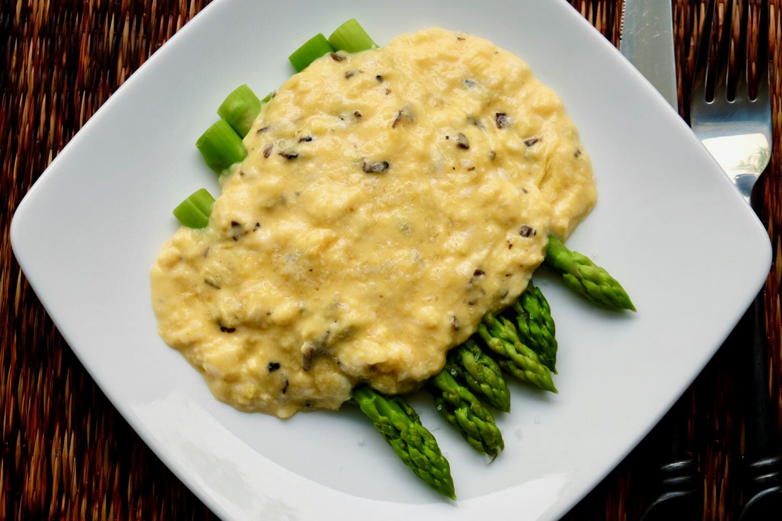 Scrambled eggs with shaved truffle on asparagus delectabilia