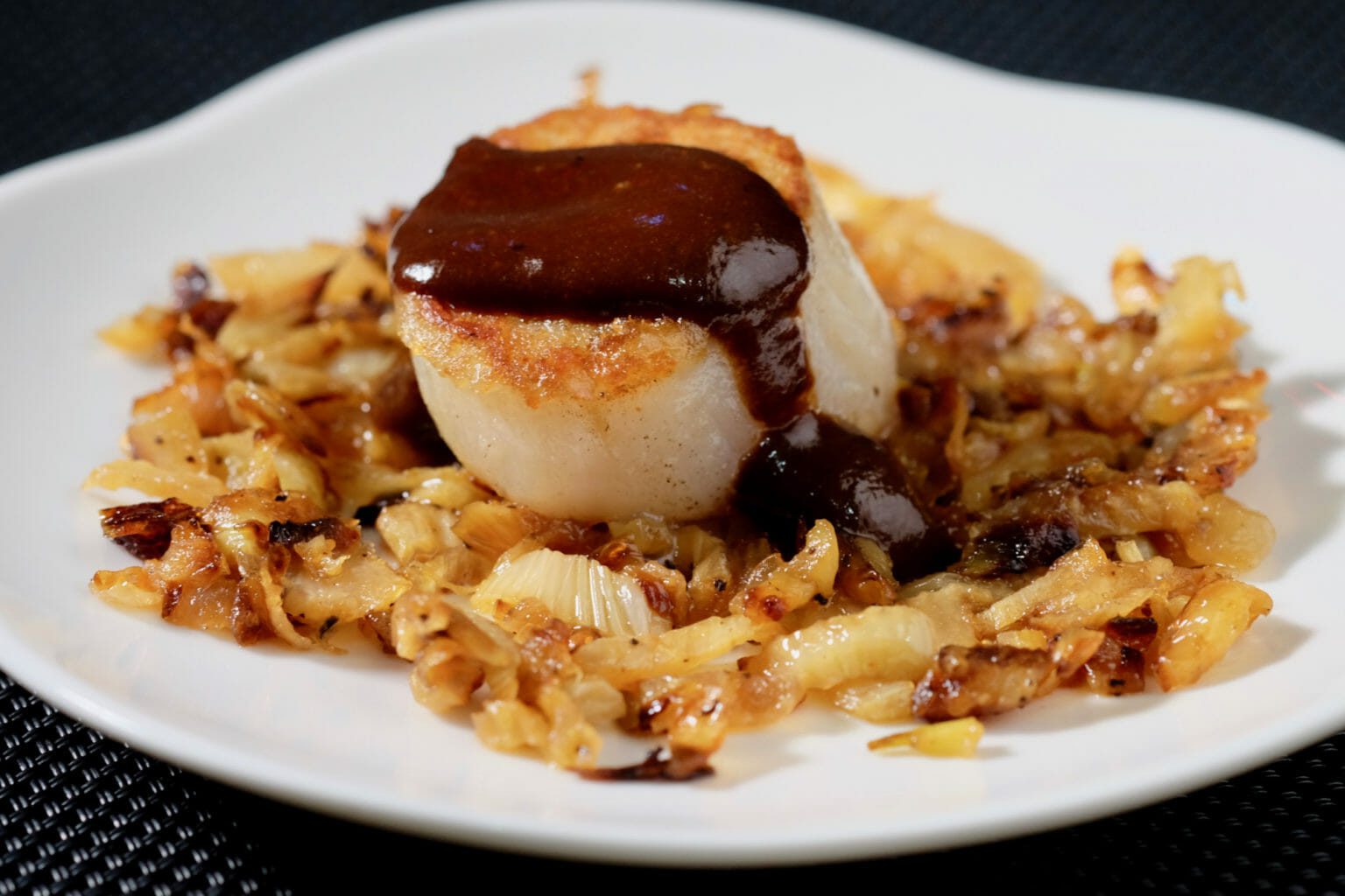 Seared scallops on caramelised fennel. Black garlic sauce. delectabilia